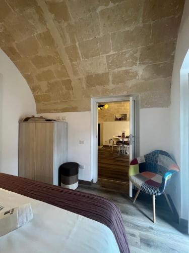 a bedroom with a bed and a chair and a table at Il Nicchio in Matera