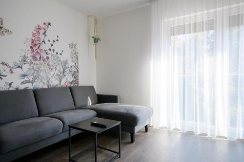 a living room with a couch and a table at Smart & Stay Aparthotel Saarbrücken Süd - Self-Check-In - Free Parking in Saarbrücken