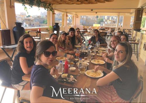 a group of people sitting around a table in a restaurant at Hotel Meerana in Jaisalmer