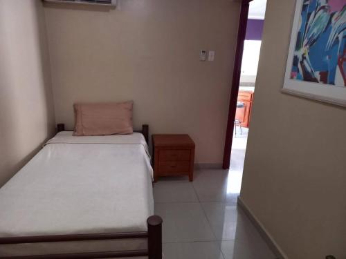 a small bedroom with two beds and a table at Pista Q hostel and apartments in Oranjestad