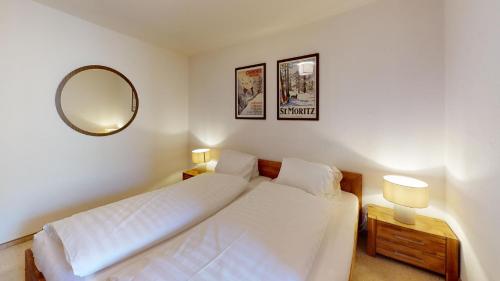 サンモリッツにあるLudains 27のベッドルーム(白いベッド1台、鏡付)