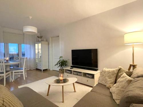 a living room with a couch and a flat screen tv at Keskuse apartment with a balcony in Haapsalu