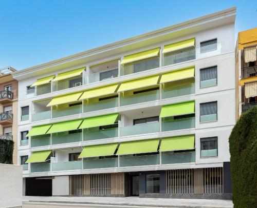 un edificio de apartamentos con balcones verdes y amarillos en Caleyro Boutique Apartments - "Parking incluido", en Fuengirola
