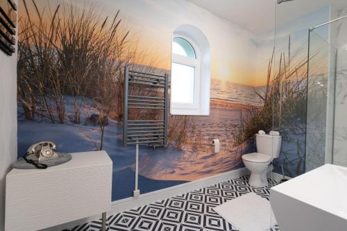 a bathroom with a wall mural of the ocean at Domaine Les Tilleuls in Wailly-Beaucamp