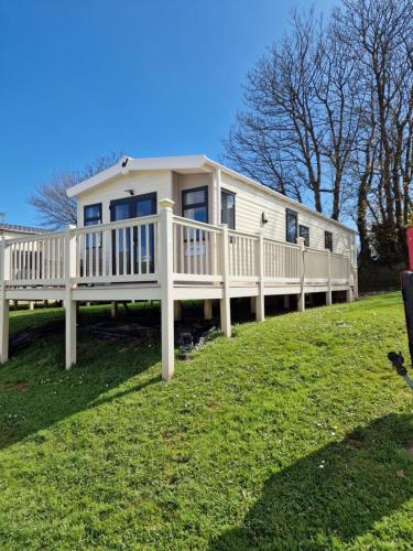 a large white mobile home on a grass field at Ocean view in Paignton