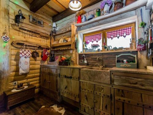 eine Küche in einem Blockhaus mit einem Waschbecken und einem Fenster in der Unterkunft Luxury Chalet Regina in Bruvno