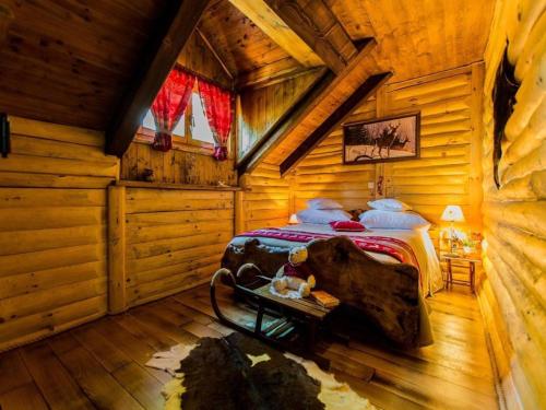 a bedroom with a bed in a log cabin at Luxury Chalet Regina in Bruvno