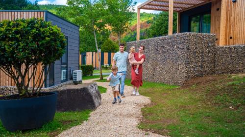 a family walking down a gravel path near a house at EuroParcs Kohnenhof in Obereisenbach