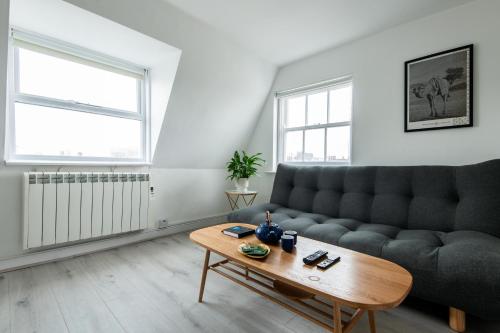 a living room with a couch and a coffee table at Newly Renovated Central One-Bedroom, 99 Steps to the Sea in Brighton & Hove