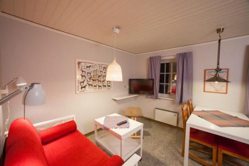 sala de estar con sofá rojo y mesa en Lullens Stugby - Lägenhetshuset 6-9 en Bruksvallarna
