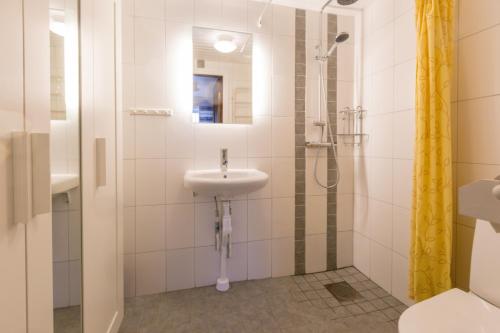 y baño con lavabo y ducha. en Lullens Stugby - Lägenhetshuset 6-9 en Bruksvallarna