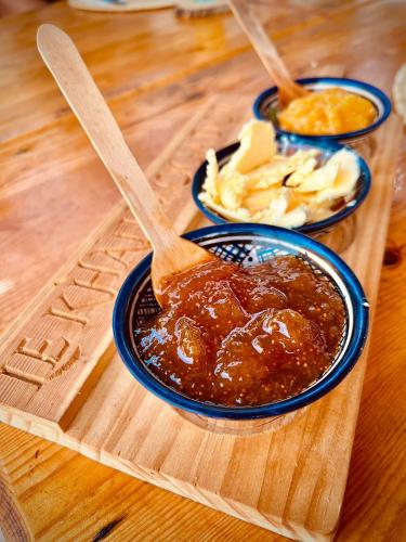 a wooden table with two bowls of barbecue sauce at Riad Le Khan Mogador in Essaouira