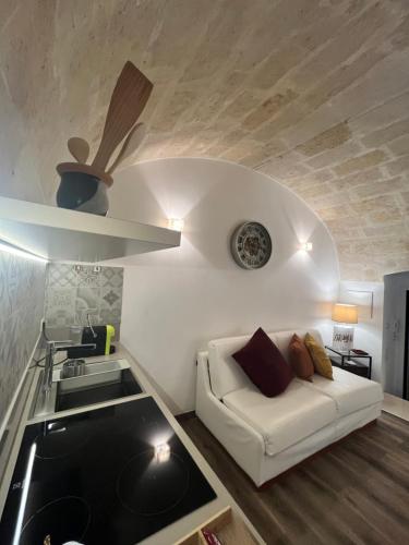 a living room with a white couch and a sink at Il Nicchio in Matera