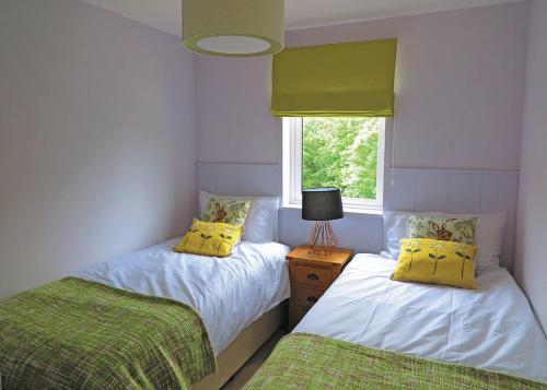 two twin beds in a room with a window at Kingswood Golf Lodges in Thorne