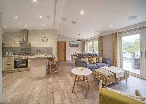 a kitchen and living room with a couch and a table at Llwyngwair Manor Holiday Park in Nevern