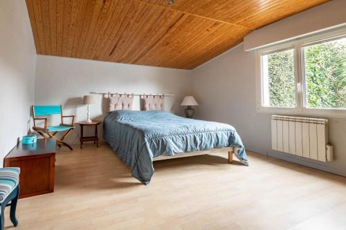 um quarto com uma cama e um tecto de madeira em Grande maison pour 10 avec piscine a Sarzeau em Sarzeau