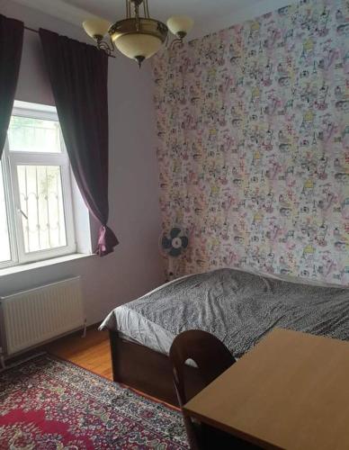 a bedroom with a bed and a table and a window at дом в новханах у моря in Baku