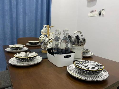 a table with plates and wine bottles on it at Rumah Putih Homestay (RPH) in Melaka