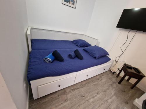 Bett mit blauen Kissen auf einem Zimmer in der Unterkunft Studio Le Galet idéalement situé en centre ville in Dieppe