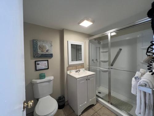 y baño con ducha, aseo y lavamanos. en Seashell Motel and International Hostel, en Key West