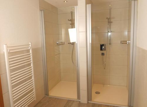 La salle de bains est pourvue d'une douche avec une porte en verre. dans l'établissement Stadlwirt Nauders, à Nauders