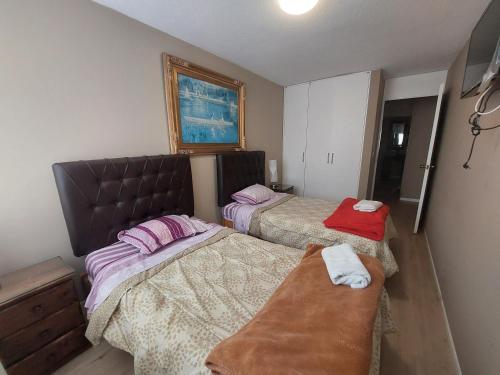 Un dormitorio con 2 camas y un banco. en Apartamento PARDO CCA, en Lima