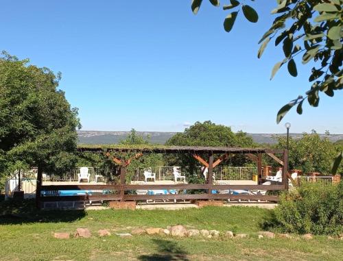 a pavilion with a pool in a park at Cabañas Mina Clavero La Amelia in Mina Clavero