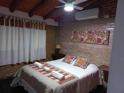 a bedroom with a bed with pillows on it at Cabañas Mina Clavero La Amelia in Mina Clavero