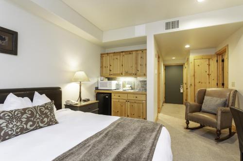 a bedroom with a bed and a chair and a kitchen at 2 Bedroom Condo - The Lodges at Deer Valley condo in Park City