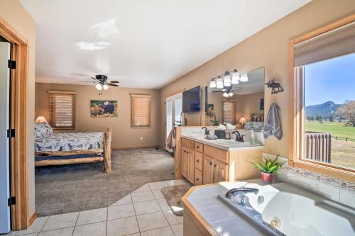 a bathroom with a tub and a sink and a bedroom at Family-Friendly Home with Hot Tub 1 Mi to Dtwn in Estes Park