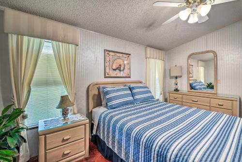 1 dormitorio con 1 cama con manta de rayas azul y blanco en Peaceful Canal-Front Retreat with Boathouse!, en Leesburg
