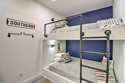 Cette chambre comprend 2 lits superposés et un mur bleu. dans l'établissement Modern Norfork House with Patio on White River!, à Norfork