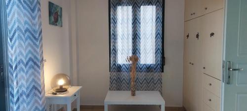 um quarto com uma janela, uma cadeira e uma mesa em Villa Viva em Asprouliánoi