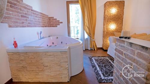 a bath tub in a room with a brick wall at B & B La Rotta in Ravenna