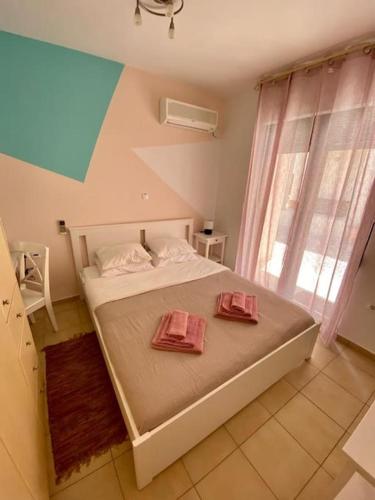 a bedroom with a bed with two pink towels on it at Villa Viva in Asprouliánoi