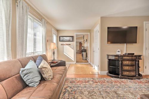 a living room with a couch and a flat screen tv at Tranquil Swansea Retreat with Fire Pit and Grill! in Swansea