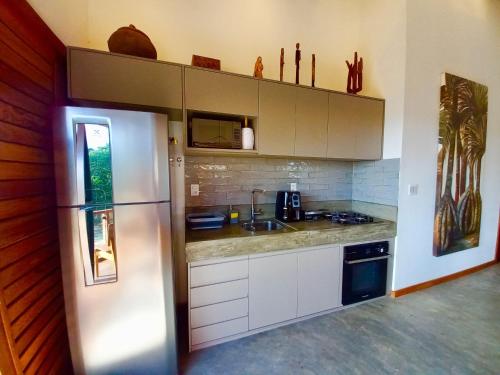 a kitchen with a stainless steel refrigerator and a sink at Oceà Privilegi - Taipu de Fora in Barra Grande