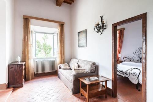 sala de estar con sofá y cama en Favolosa Villa in Toscana, en Lucignano