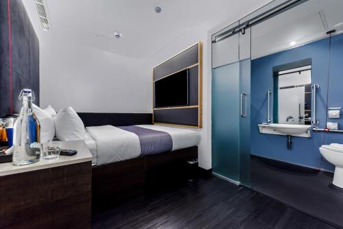 Habitación con cama, lavabo y baño. en The Z Hotel Holborn, en Londres