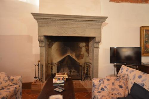 a living room with a fireplace and a tv at Favolosa Villa in Toscana in Lucignano