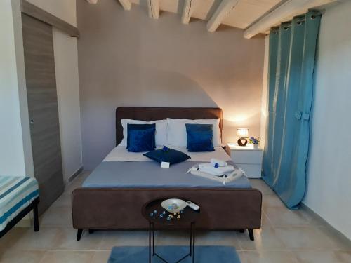 una camera da letto con un grande letto con cuscini blu di Ettore Casa Vacanze a Comiso