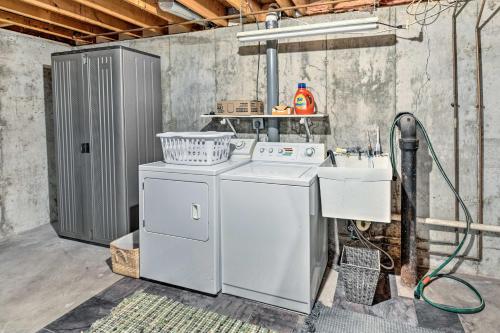 eine Waschküche mit einer Waschmaschine und einem Waschbecken in der Unterkunft Airy Cottage Close to Rock Lake with Fire Pit! in Lake Mills
