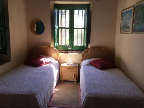 two twin beds in a room with a window at Cottage Torre Elena - Staletti in Stalettì
