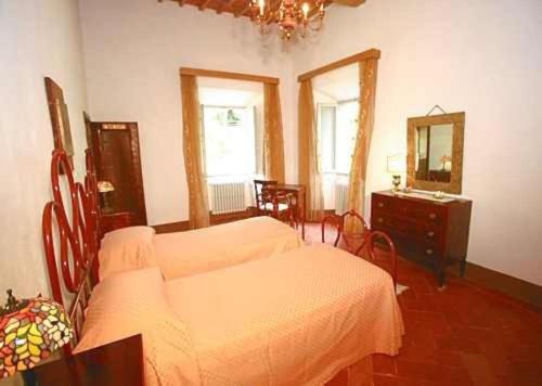 a bedroom with a bed and a dresser and a mirror at Favolosa Villa in Toscana in Lucignano