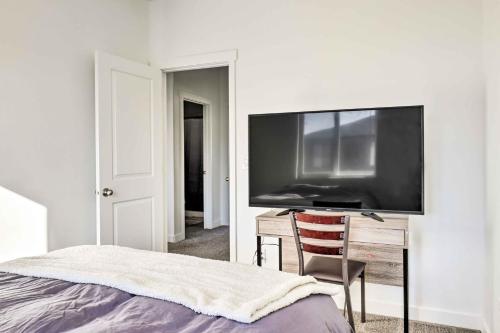 a bedroom with a large flat screen tv on a wall at Modern Townhome - 8 Mi to Thanksgiving Point! in American Fork
