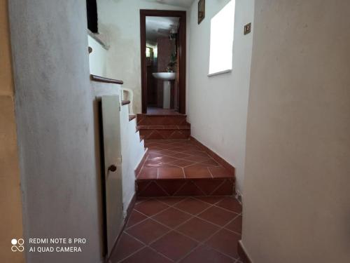 a hallway with a staircase with red tiles on the floor at La Casetta del Custode in Villa Santa Maria