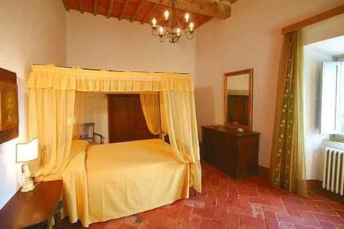 a bedroom with a bed and a dresser and a mirror at Favolosa Villa in Toscana in Lucignano