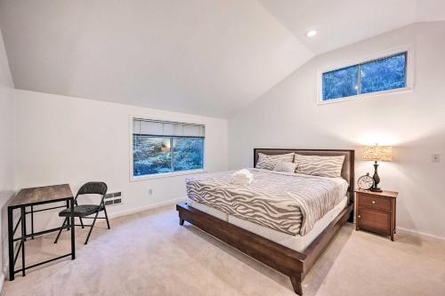 a bedroom with a bed and a desk and two windows at Cozy Redmond Retreat Spacious Deck and Yard! in Redmond