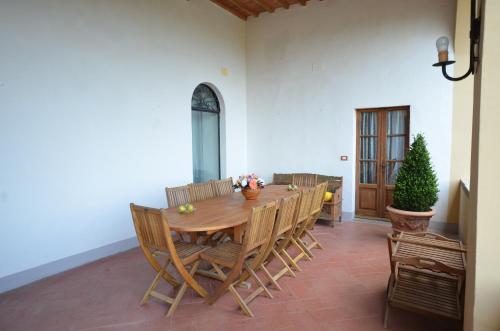 a dining room with a wooden table and chairs at Favolosa Villa in Toscana in Lucignano