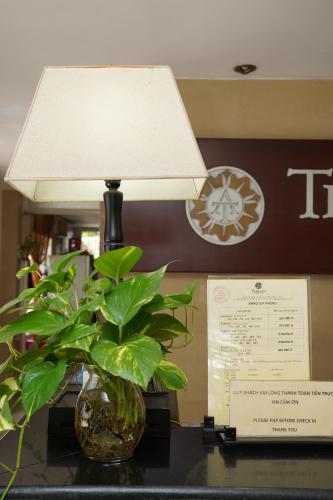uma lâmpada em cima de uma mesa com uma planta em Trang An Hotel - 10 minutes Landmark 81 em Cidade de Ho Chi Minh